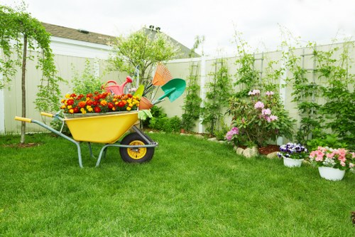 Gardener wearing PPE and training a colleague on equipment use